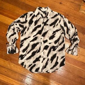 Black and cream zebra print button up blouse with tie at wrist and ruffle cuff